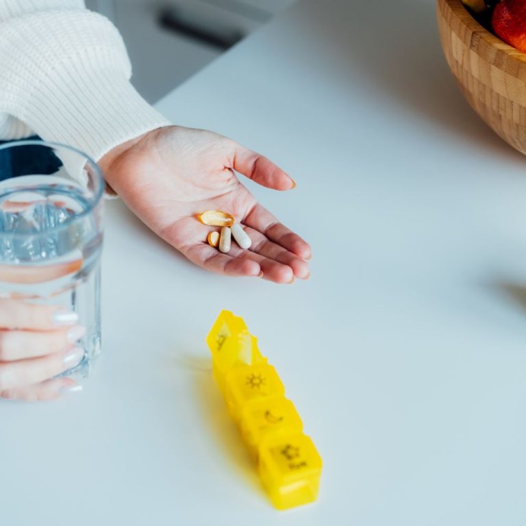 close-up-female-hands-holding-pills-and-glass-of-w-2025-02-12-06-52-22-utc (1)